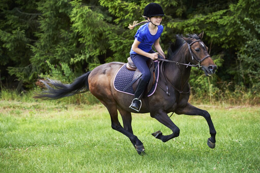 side-view-of-girl-wearing-riding-hat-galloping-on-horseback-632168831-5ace5d2a6bf069003842c47b